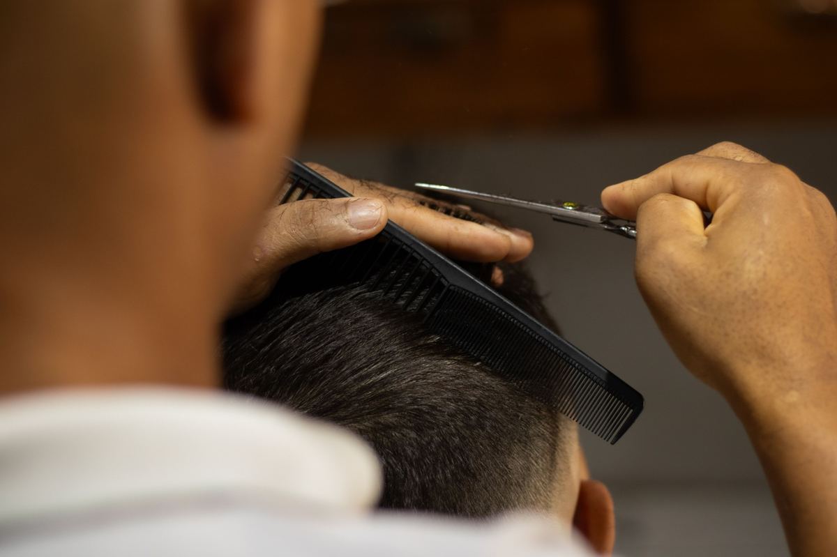 Barbero cortando con tijera y peine